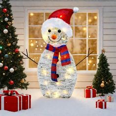 a snowman with a red hat and scarf standing in front of a christmas tree