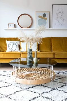 a living room with yellow couches and art on the wall above it is a coffee table