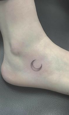 a small crescent tattoo on the ankle