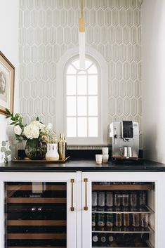 a kitchen with white cabinets and black counter tops, along with a window in the wall