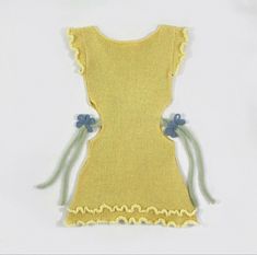 a yellow knitted dress with blue flowers on the side and green ribbon around the waist