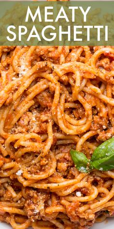 a plate full of spaghetti with basil on top