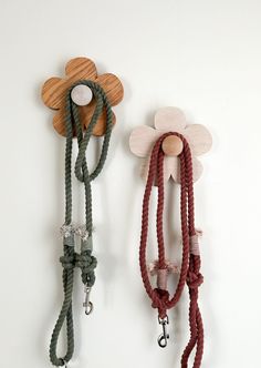 two leashes with flowers attached to them hang on the wall next to each other