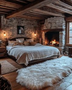 a rustic bedroom with stone walls and wood flooring is lit by warm lighting from the windows