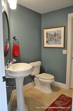 a bathroom with a sink, toilet and mirror