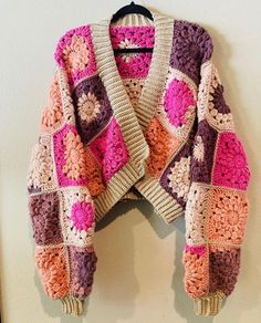 a crocheted jacket hanging on a wall