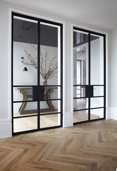 an empty room with glass doors and wooden floors