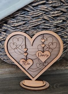 a wooden heart with two hearts on it and the word love is written in cursive writing