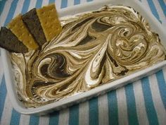 a white plate topped with cake and crackers on top of a blue and white table cloth