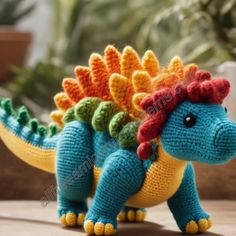 a crocheted toy dinosaur with a red flower in it's hair sitting on a table