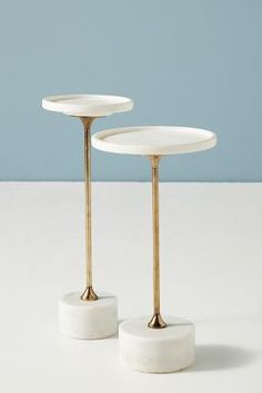 two white marble and gold plated candlesticks, one on top of the other