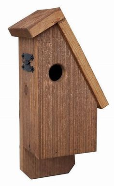 a wooden birdhouse with a hole in the roof