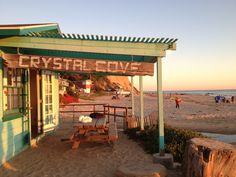 a sign that reads crystal cove on the side of a building next to a beach