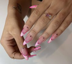 a woman's hands with pink and white nail designs on their nails, holding a diamond ring