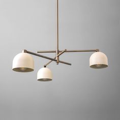 three lights hanging from a ceiling fixture in a room with gray walls and flooring