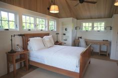 a bed sitting in a bedroom next to two desks and a ceiling fan on top of a wooden floor