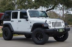 a white jeep is parked on the street