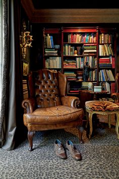 a pair of shoes sitting on the floor in front of a chair and bookshelf