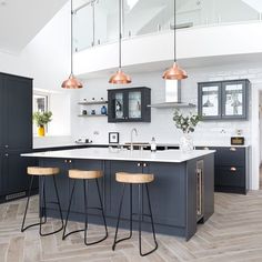 a kitchen with two bar stools next to an island in the middle of it