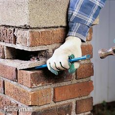 a person wearing white gloves and holding a blue tool in front of a brick wall