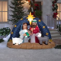 a nativity scene in front of a house decorated for christmas