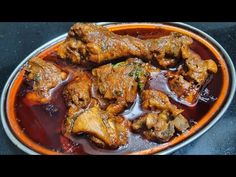 a bowl filled with meat and sauce on top of a table