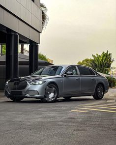 a silver car parked in front of a building next to a parking space with no cars