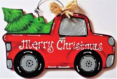 a christmas ornament with a red truck carrying a tree on it's back