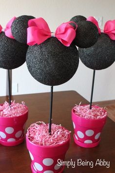 a minnie mouse centerpiece with pink bows on it's head in a cup