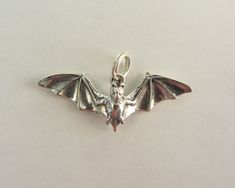 This is a cute little sterling silver 3D bat charm. It is in mint condition as it is new and handmade. It was acid tested for sterling and it does not have a stamp. Thanks for looking ! Bat Pendant, Flying Bat, Charm It, Jewelry Supplies, Custom Jewelry, Charm Pendant, Mint Condition, Floral Rings, Jewelry Shop