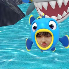 a young boy is floating in the water next to a shark with his mouth open