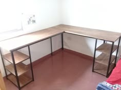 a corner desk with shelves on each side and a red blanket on the floor next to it