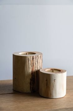 two wood candle holders sitting on top of a wooden table