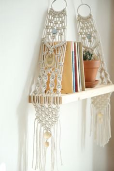 a book shelf with two books on it and some tassels hanging from the wall