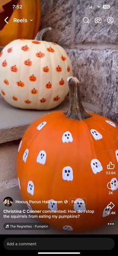 two pumpkins sitting on the steps with ghost faces painted on them, one is orange and the other is white