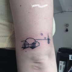 a person with a small tattoo on their arm that has an image of a building