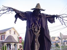 a scarecrow is standing in the middle of a street with his arms outstretched and hands out