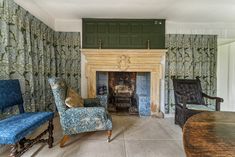 a living room filled with furniture and a fire place next to a wall covered in curtains