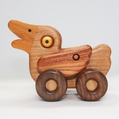 a wooden toy car with wheels on a white background, it looks like a bird