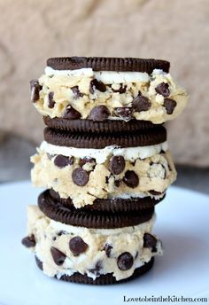 four cookies and cream ice cream sandwiches stacked on top of each other with chocolate chips