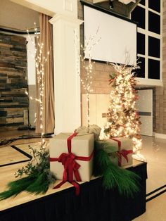 two wrapped presents sitting on top of a wooden box in front of a christmas tree