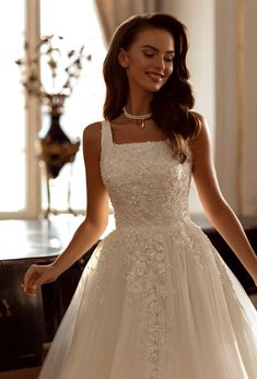 a woman in a white wedding dress standing next to a piano