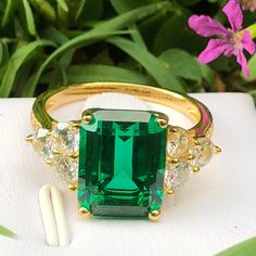 an emerald ring with three diamonds on it