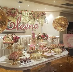 a table topped with lots of desserts and balloons