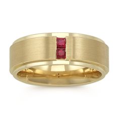 a yellow gold wedding ring with a red stone in the center and a thin band