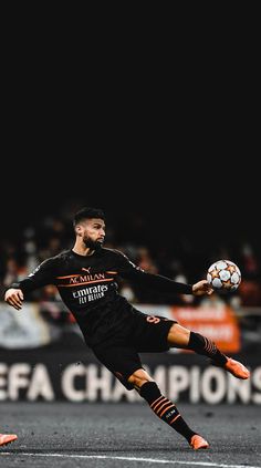 a man kicking a soccer ball in the air with his foot and arm extended, during a game