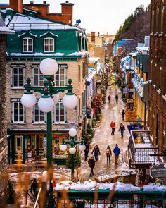 people are walking down the street in an old town with lots of snow on the ground