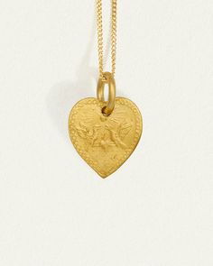 Graced with eagle reliefs on both sides, this solid gold heart necklace embodies bravery and love. The design draws inspiration from the Latin word for heart, originally signifying the courageous expression of one's true feelings.  
 Crafted from 24k solid gold, this double-sided pendant exudes a rich, tactile lustre that enhances its allure. A 14k yellow gold curb chain completes the Courage Necklace. Symbolic Yellow Gold Heart Jewelry, Commemorative Gold Jewelry With Large Pendant, Gold Large Pendant Jewelry For Commemoration, Symbolic Yellow Gold Heart Pendant Jewelry, Symbolic Gold Jewelry With Heart Charm, Gold Engraved Medallion Heart Necklace, Gold Heart Pendant Jewelry With Large Pendant, Gold Heart Pendant Large Jewelry, Heart Shaped Necklaces For Valentine's Day Commemoration