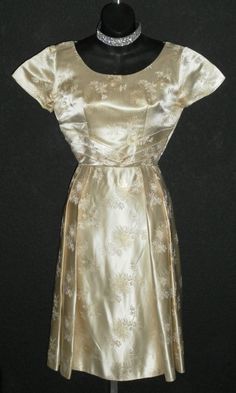 "In excellent condition, this dress has been stored away for 3/4 of a century or more, just to resurface here! It is gold satin brocade, custom made in Okinawa, Japan, as per the tag. It has a metal zipper, petite sizing. The bust will fit 34\", waist is 24\", hips free fitting to 50\", length is 43\", arm openings 12\" circumference, shoulders 15\", sleeves 5.5\"." Formal Gold Silk Dress, Gold Silk Dress For Formal Occasions, Formal Gold Brocade Dress, Gold Silk Dress With Fitted Bodice, Gold Silk Dress With Gold Embroidery, Ceremonial Silk Fitted Dresses, Vintage Fitted Dresses For Church, Vintage Brocade Party Dress, Vintage Silk Formal Dresses