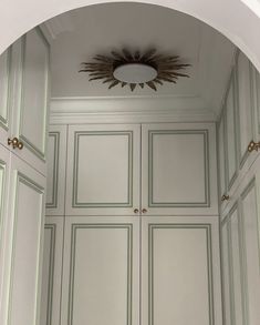 an archway leading into a bathroom with white walls and green trim on the doors,